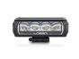 Front view of the lamp face showing the lens and central light source, with the housing and bezel clearly visible.